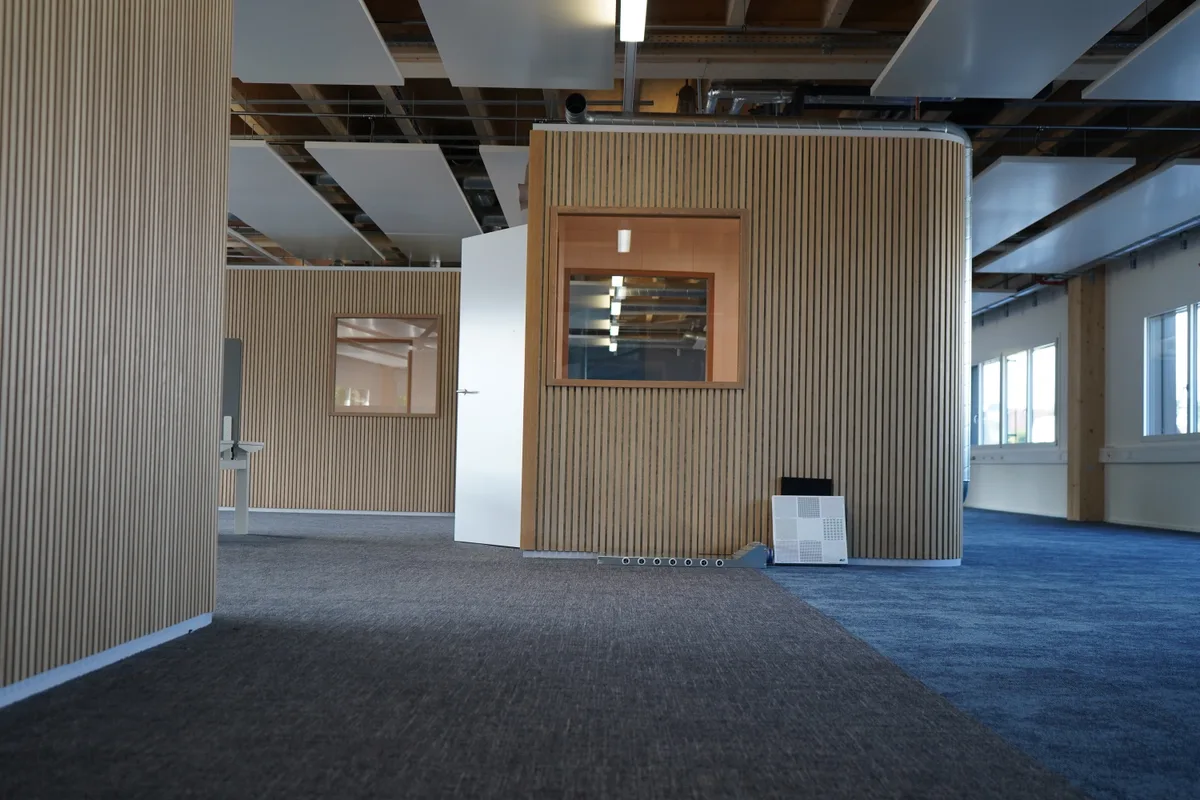 Holzboxen in einer Halle.